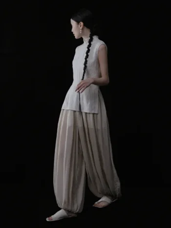 Full side silhouette of a beige pinstripe cheongsam collar top, showcasing the elegant tailored cut, side slit detail, and classic high mandarin collar of this cheongsam style top.
