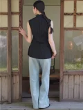 Full back view of a black chinese qipao top paired with wide leg jeans, featuring a high mandarin collar and tailored fit, a timeless top qipao for retro and modern styling.