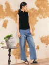 Model wearing black sleeveless velvet mandarin collar qipao style blouse, paired with jeans for casual chic look