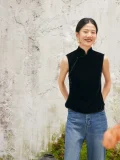 Model wearing black sleeveless velvet mandarin collar qipao style blouse, paired with jeans for casual chic look