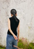 Back view of black sleeveless velvet mandarin collar qipao style blouse, showing smooth velvet fabric and tailored fit