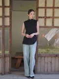 Casual styled black qipao top paired with wide leg jeans, featuring a traditional mandarin collar and sleeveless pinstripe design, a versatile chinese qipao top for daily wear.