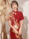 Close-up of an embroidered qipao wedding dress bodice, highlighting the delicate gold and white floral embroidery on a rich red fabric, a key feature of traditional chinese wedding dress qipao.