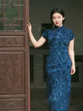 Full-length plus size Chinese qipao dress in blue velvet, showing classic silhouette against traditional wooden door