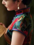 Close-up of the neckline and shoulder detail of a mulberry silk vintage qipao dress, showcasing the smooth silk texture and colorful piping trim.