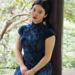 Plus size Chinese qipao dress in blue floral velvet, elegant fit for curvy women in outdoor garden setting