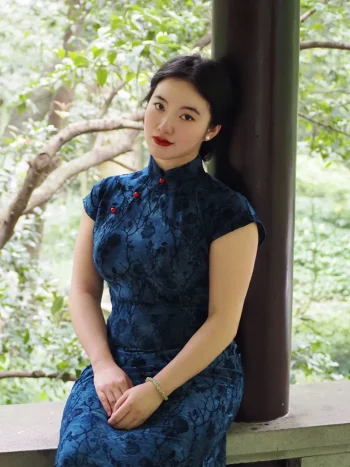 Plus size Chinese qipao dress in blue floral velvet, elegant fit for curvy women in outdoor garden setting