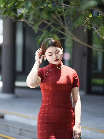 Plus size red long cheongsam in outdoor setting, full-length elegant qipao for curvy women