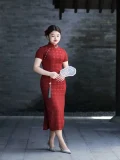 Plus size red long cheongsam with traditional fan, full-length qipao in classic Chinese setting