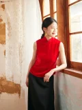 Side view of woman sitting in red cheongsam blouse, modern cheongsam style velvet top