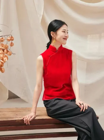 Woman sitting in red cheongsam style blouse, sleeveless modern chinese cheongsam top