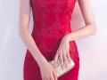 Close up of the waist detail on a red lace qipao wedding dress, showcasing the delicate lace pattern and fitted bodice for a flattering bridal fit.
