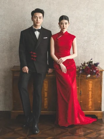 Full body couple wedding portrait, bride in red long train wedding cheongsam (qipao) leaning on vintage wooden cabinet, classic chinese bridal dress for wedding ceremony