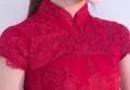 Close up of the traditional mandarin collar on a red wedding qipao, highlighting the intricate floral lace embroidery, a key feature of premium lace qipao dress designs.