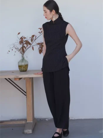 Side view of a sleeveless black qipao top with a form-fitting silhouette and traditional mandarin collar, showcasing the elegant cut of this classic chinese qipao top.