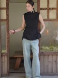 Styled look of a versatile black qipao top for daily wear, featuring a traditional mandarin collar, sleeveless cut, and relaxed tailored fit, a premium chinese qipao top for all occasions.