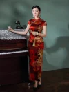 Woman in a 19 mome mulberry silk red floral long qipao standing beside a vintage piano, holding a tassel fan to show the dress's elegant drape and rich floral design.