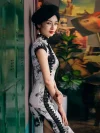 Side view of woman leaning against wall in 1920s Shanghai Chinese silk cheongsam, featuring black lace trim, ink-wash bamboo print, and elegant high slit design.