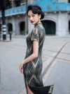 Side profile view of a woman in a 1930s long qipao with dark green brown mulberry silk fabric, highlighting the dress's back silhouette, short sleeves, and flowing abstract print against a vintage city backdrop.