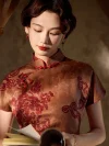 Close-up shot of a woman in a 1930s reddish-brown floral silk qipao, reading a book while highlighting the intricate red floral print, traditional mandarin collar, and handcrafted knot buttons on the placket.