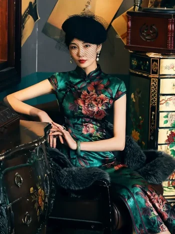 Vintage Old Shanghai style 19 Mome mulberry silk women's cheongsam with green peony print, featuring a model seated in a retro room with classic furniture, wearing a black net hat and fur shawl.