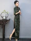 Model standing in a custom long qipao with 3/4 sleeves, holding a traditional fan, showing the elegant side profile and bamboo print details.