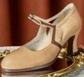 Detailed shot of 1920s vintage beige genuine leather qipao Mary Janes, focusing on the soft leather texture, brown contrast trim stitching, and geometric cutout details against a golden mirror background.