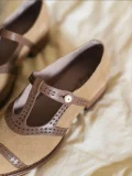 Closeup detail of beige Lolita vintage Mary Jane T-strap flat shoes, showing the intricate cutout leather strap and pearl-like button accent, perfect for vintage cheongsam outfits