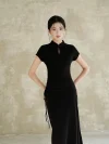 Woman standing with hands on hips, wearing a black qipao dress. This women qipao showcases its slim fit design, adjustable side drawstrings, and elegant silhouette from the front.