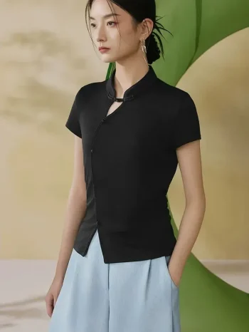 A woman models a black modern qipao inspired top with traditional Chinese mandarin collar and delicate frog buttons, paired with light blue wide-leg pants.