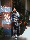 Black and white 1920s Qipao dress goat leather shoes with classic cutout details, worn with a traditional Republican era outfit by a model standing at Duolun Road brick wall, showing vintage cheongsam styling.