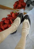 Two-tone black and white Margarita 1920s vintage schoolgirl leather Qipao Mary Jane shoes worn with lace-patterned white socks, styled with red rose petals for old Shanghai aesthetic.