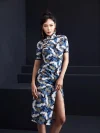 Full front view of a woman wearing a blue crane print slim-fit midi cheongsam dress, highlighting the intricate crane and floral print, short sleeves with black trim, and tailored fit of this elegant midi cheongsam.