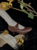Vintage display of brown leather Mary Jane qipao shoes paired with white lace knit socks, styled with dried roses for an old-fashioned romantic look