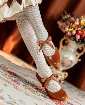 Close-up of vintage genuine leather qipao shoes with butterfly ribbon detail, worn on crossed legs with white knit socks, showcasing the elegant ribbon mary jane design perfect for both cheongsam and lolita fashion