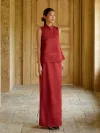 Burgundy Modified Qipao With Pants (or Skirt) - Side profile view of woman in two-piece burgundy qipao set, sleeveless brocade top and matching long skirt, standing in a sunlit stone hallway, elegant modern chinese dress