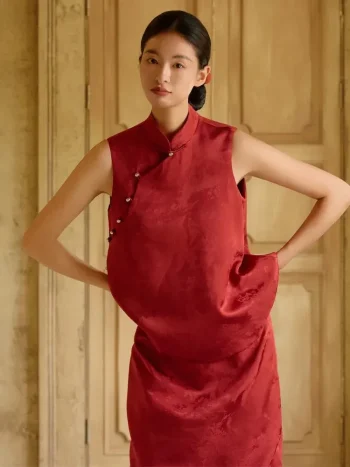 Burgundy Qipao - Close-up of modified two-piece qipao with pants set, showcasing sleeveless mandarin collar brocade top with diagonal pearl frog buttons, highlighting fabric texture and tailored fit
