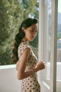 Model looking back by the window in a cap sleeve cotton qipao dress with polka dot print, capturing the soft retro charm of classic Hong Kong cheongsam fashion.