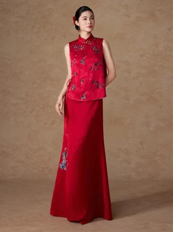 Model wearing the Chinese Red Long Modified Qipao Dress Two Piece, a red stand collar long modified cheongsam with delicate floral embroidery, featuring a sleeveless vest and matching floor-length skirt, showcasing elegant traditional qipao chinese style in a minimalist studio.