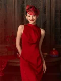 A bride poses in a bold red wedding cheongsam dress, paired with a traditional red paper cut headpiece that echoes Chinese wedding traditions. This elegant cheongsam wedding dress features a fitted silhouette ideal for modern brides.