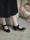 Close-up view of black 1920s replica cheongsam leather shoes paired with floral lace socks, classic mary jane qipao shoes