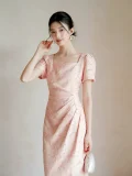 Close-up shot of women's summer modified cheongsam, elegant new Chinese waist cinched pleated dress in light pink with textured fabric, square neck puff short sleeve for refined summer wear