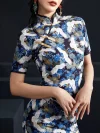 Close-up shot of a woman wearing a blue crane print slim-fit midi cheongsam, focusing on the mandarin collar, traditional golden frog buttons, and intricate crane and floral print details on this elegant blue cheongsam dress.