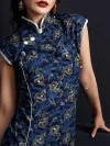 Close-up shot of a woman wearing a dark blue peacock print short cheongsam, focusing on the silver frog buttons, mandarin collar with white trim, and intricate peacock pattern on this fashion cheongsam dress.