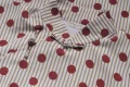 Macro shot of a cotton qipao dress showcasing the intricate traditional frog button and lightweight, high-quality fabric with polka dot print.