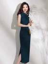 Side view of women's elegant dark green qipao with high slit, rose jacquard fabric and red buttons, model holding a folding fan, highlighting the slit design.