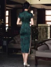 Back view of a woman in dark green vintage floral qipao, walking to show the hidden back zipper and elegant full-length silhouette.