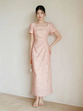 Full-body view of women's summer modified cheongsam, new Chinese style long dress with square neck puff sleeve, waist cinched pleated design in soft pink textured fabric for weddings & summer parties