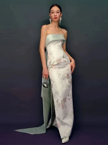 Full-length shot of strapless modern qipao prom dress, mint green and white jacquard fabric with side slit, paired with a mini handbag for prom styling.