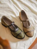 Pair of Lolita vintage Mary Jane flat shoes in green and beige, featuring T-strap cutout leather design, displayed on white bedding for retro cheongsam styling